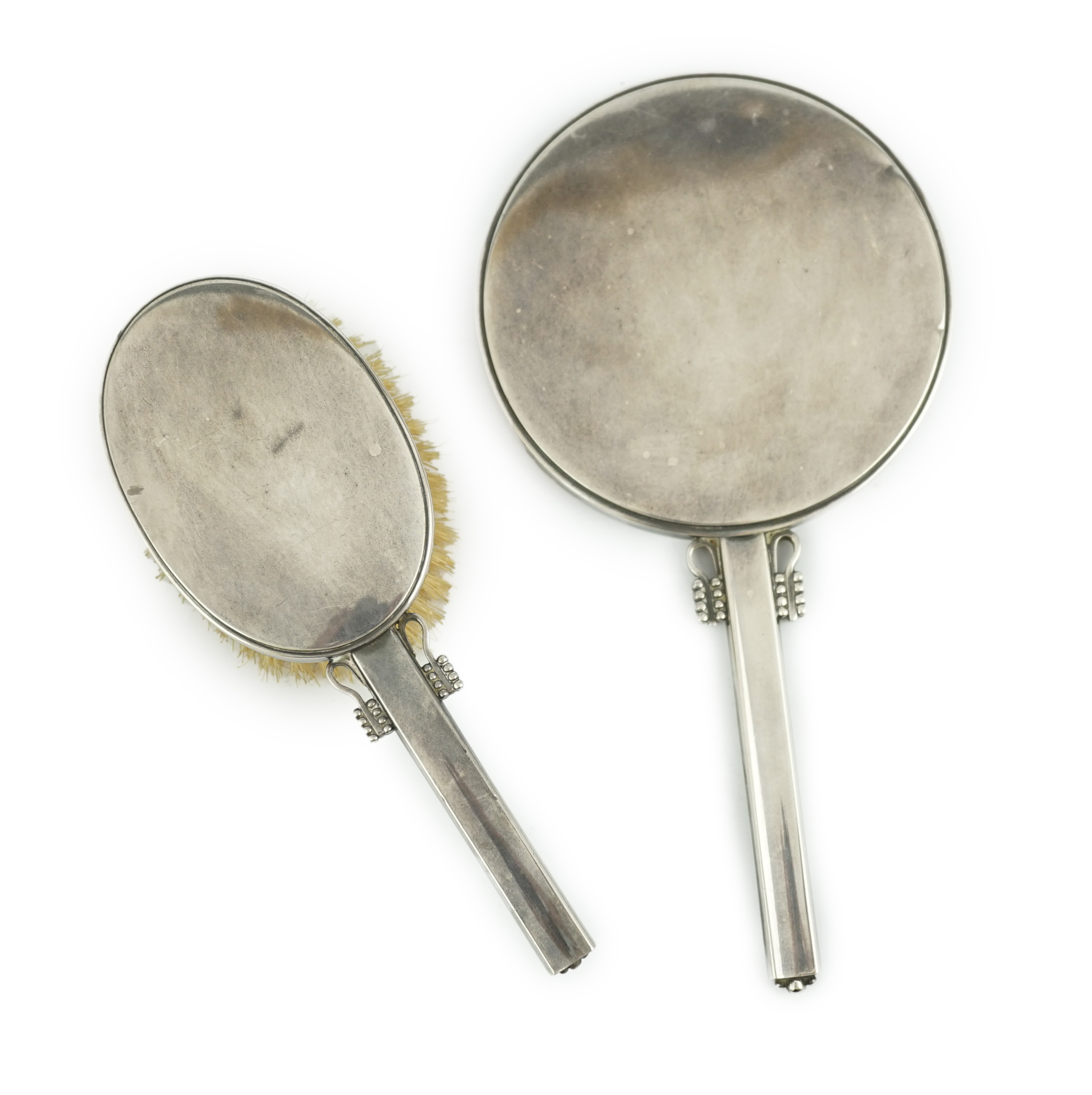 A 1950's Harald Nielson for Georg Jensen silver mounted hand mirror and matching hair brush